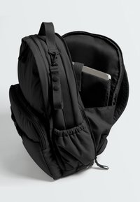 Black backpack with open main compartment showing a laptop in padded sleeve, side pockets, and adjustable shoulder strap.