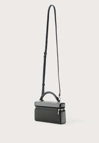 Piccola borsa nera con una forma strutturata, caratterizzata da una parte superiore texturizzata con accenti argentati, una maniglia superiore e una tracolla regolabile.