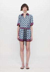 Rochie cu mânecă scurtă, albastră și albă, cu un model și accente roșii, talie strânsă și șnur negru. Material neted și croială lejeră.