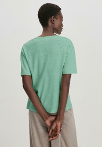 Mintgroene T-shirt met korte mouwen, een relaxte pasvorm en een ronde halslijn. Lichte, geweven stof met een casual ontwerp. Geen zichtbare merkuiting.