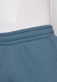 Puma LOGO PANTS - Teplákové kalhoty - gray skies