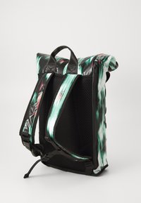 Sac à dos roulé en noir brillant, avec des motifs ondulés verts et rouges. Il dispose d'un dos en maille rembourrée et de bretelles ajustables pour le confort.