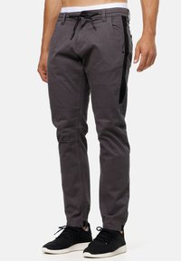 Gray cotton blend pants with a slim fit, featuring black side panels, front pockets, and an adjustable drawstring waistband.
