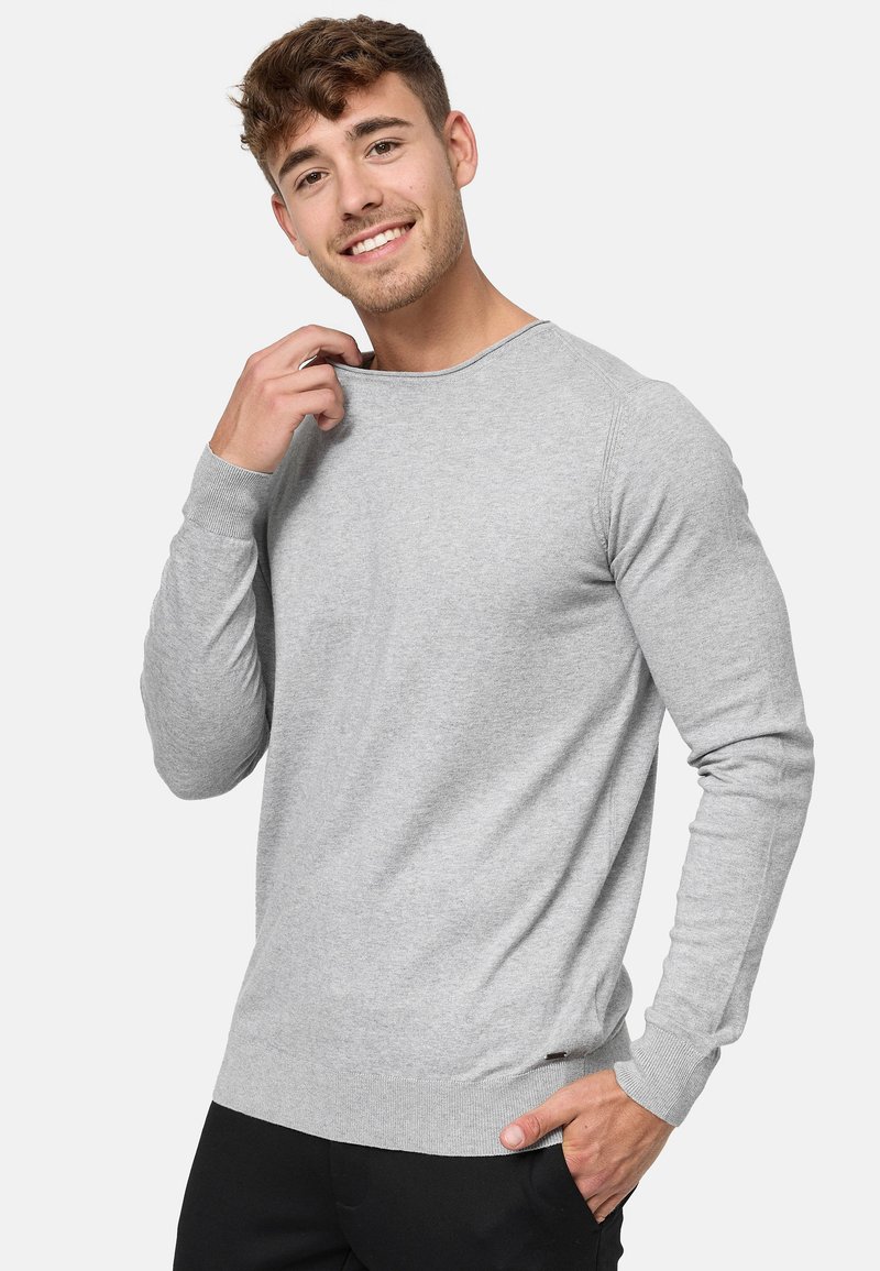 Suéter gris claro hecho de una tela suave, con mangas largas, cuello redondo y puños y dobladillo acanalados.