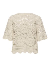 Haut en crochet crème à manches courtes avec des motifs en dentelle circulaires et floraux complexes et un ourlet festonné.