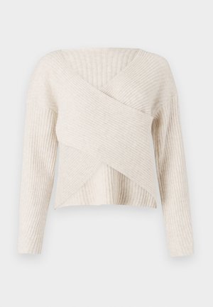 Cream ribbed sweater with a crossover design, long sleeves, and a soft texture. Features a V-neckline and a cropped silhouette.