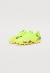 Bright yellow soccer cleats with pink accents, textured material, and a patterned design. Features lace closure and molded studs for traction.