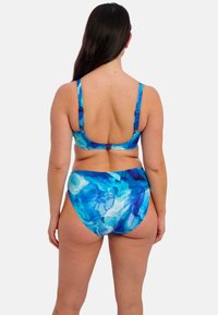 Ensemble de bikini à motifs bleus et turquoise avec des bretelles réglables, un dos échancré et un bas taille haute. Texture de tissu lisse.