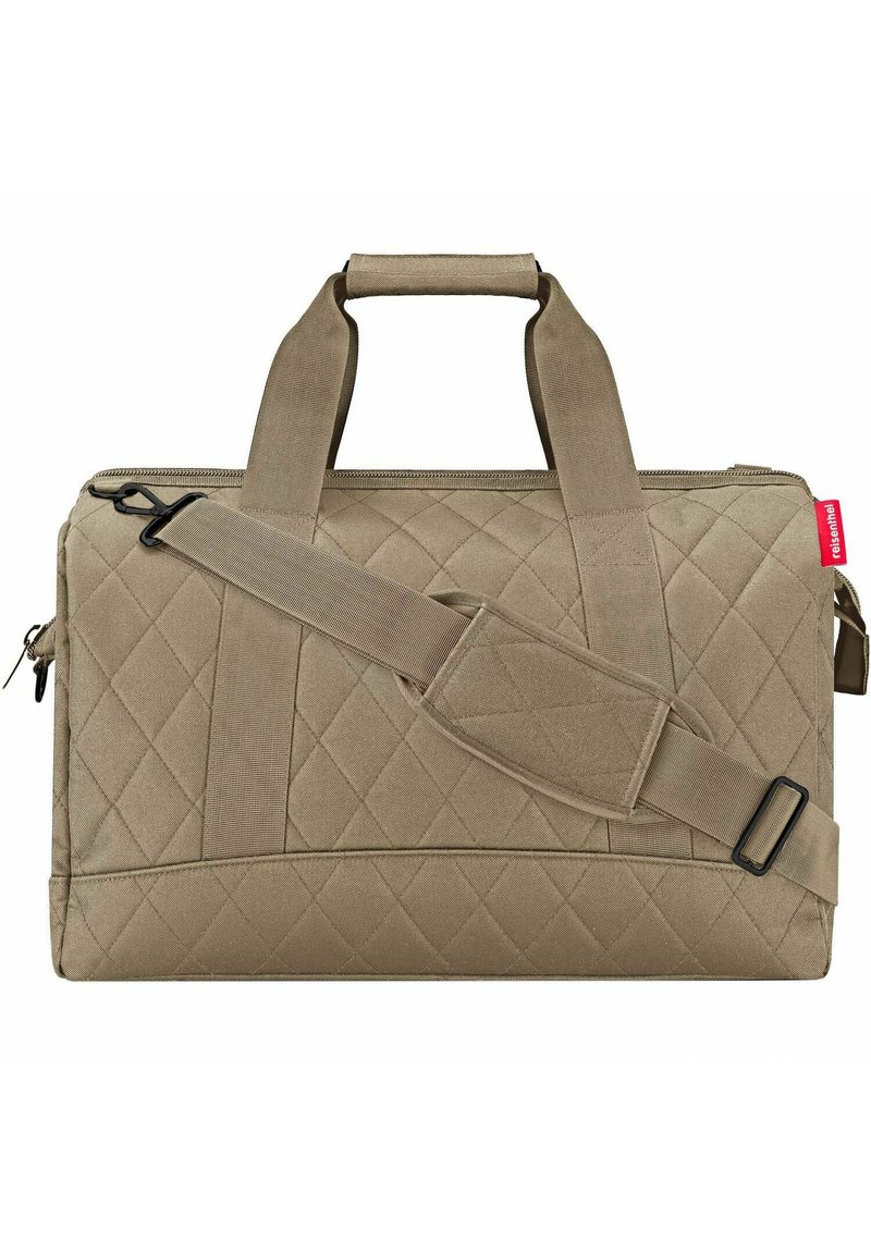 Bolso de tela acolchada en color beige con dos asas superiores y una correa para el hombro ajustable. Presenta un cierre de cremallera y una etiqueta de la marca.