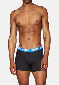 Schwarze Boxer-Shorts mit einem blauen Puma-Logo auf dem Bund, ausgestattet mit einem figurbetonten Design und glattem Baumwollstoff für Komfort.