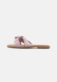 Flate sandaler med en knyttet overdel i lys rosa sateng, med en brun gummisåle og minimalistisk design. Glatt tekstur hele veien.
