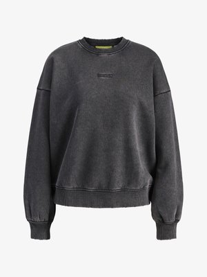 Temno siva pulover iz bombažnega mešanice, s krožnim izrezom, spuščeno rameni ter rebrastimi manšetami in robom. Diskretna logotip blagovne znamke na prsih.