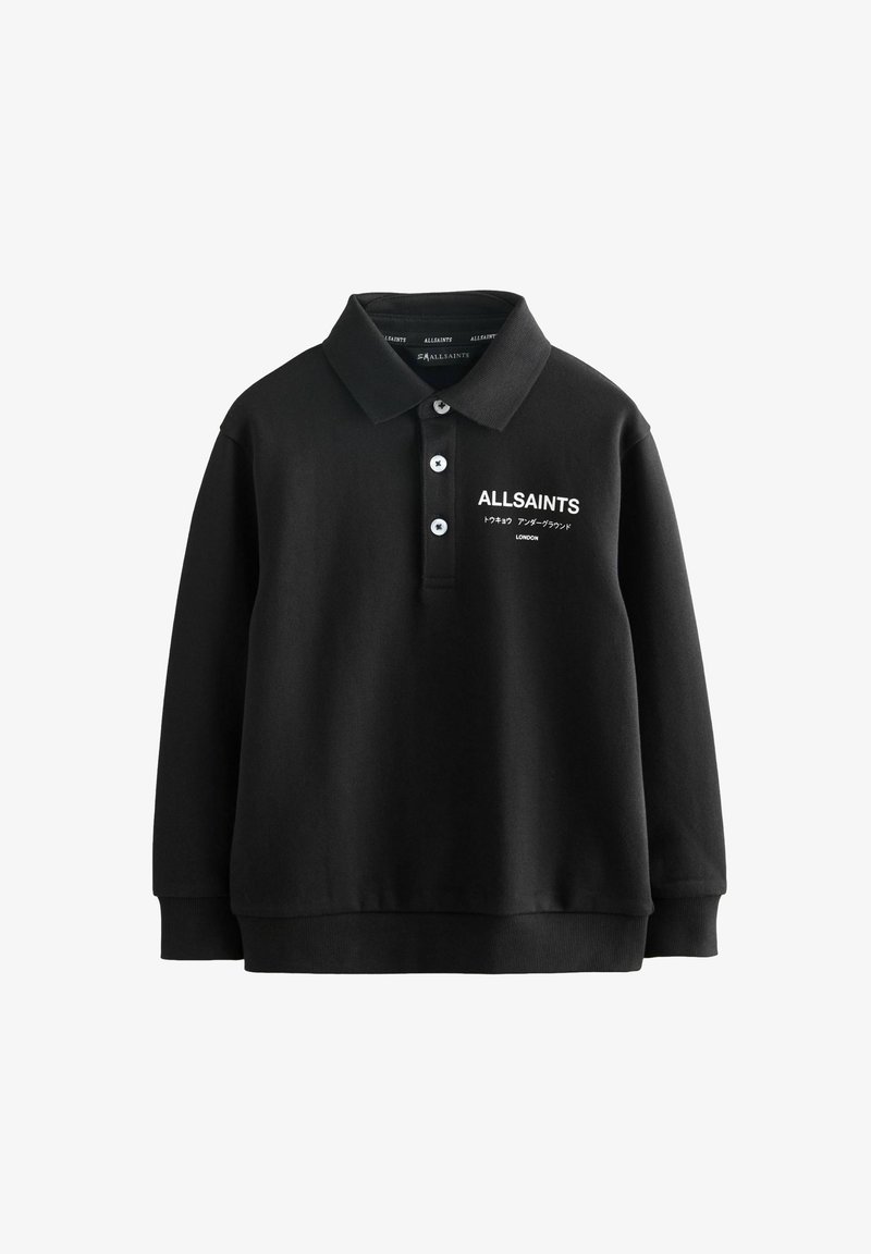Črna polo majica iz mešane bombažne tkanine, z ovratnikom, zapenjanjem na tri gumbe in belim napisom logotipa na levem prsnem delu. Dolgi rokavi.