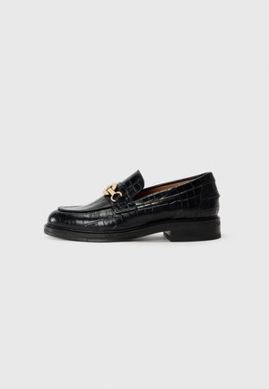 Black leather loafers with a crocodile texture, featuring a gold-tone hardware accent and a stacked heel. Classic slip-on design.
