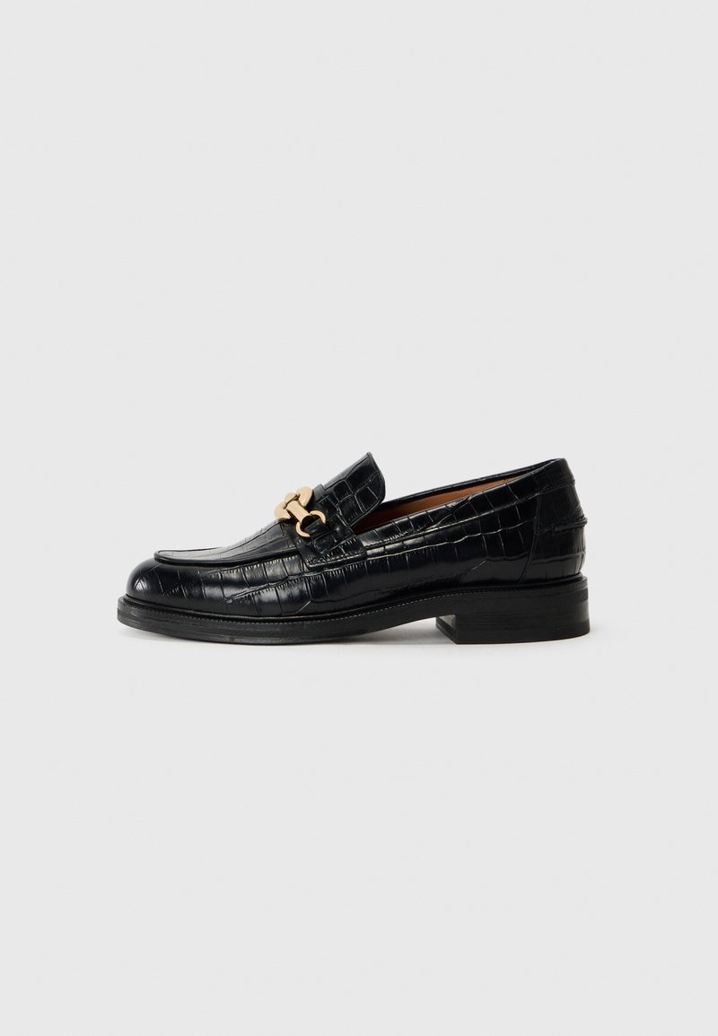 Sorte lær loafers med krokodillestruktur, med en gullfarget detalj og en stablet hæl. Klassisk slip-on design.