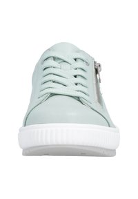 Jasnoniebieski sneaker z sznurowanym przodem, białą karbowaną podeszwą i srebrnym zamkiem błyskawicznym po boku, widziany z przodu.