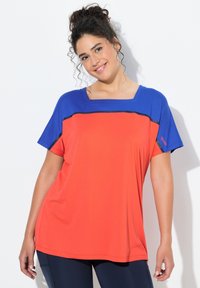 Czerwona i niebieska sportowa koszulka z kwadratowym dekoltem, krótkimi rękawami i czarnymi poziomymi paskami na wysokości klatki piersiowej. Wykonana z oddychającej tkaniny.