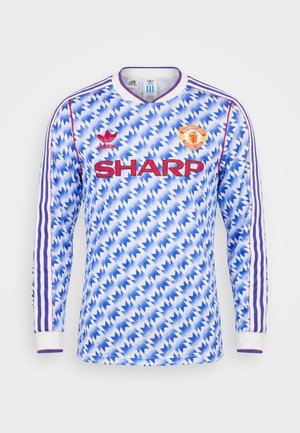 Maillot de football à manches longues de Manchester United avec motif zigzag bleu, logo Sharp rouge, logos Adidas et bandes violettes sur manches blanches.