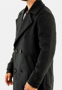 Abrigo de mezcla de lana negra con diseño de doble botonadura, grandes solapas, cierres con botones y bolsillos laterales. Tejido texturizado con detalle de logotipo.