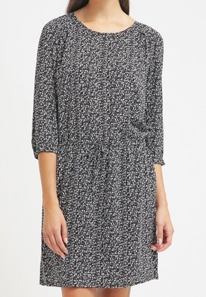 Robe à motif noir et blanc avec un col rond, des manches trois-quarts et une taille élastique pour un ajustement décontracté. Texture du tissu lisse.