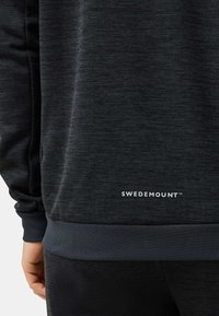 Zwarte sweatshirt van gestructureerde stof, met ribgebreide manchetten en zoom. "SWEDEMOUNT" logo in het wit gedrukt op de taille.