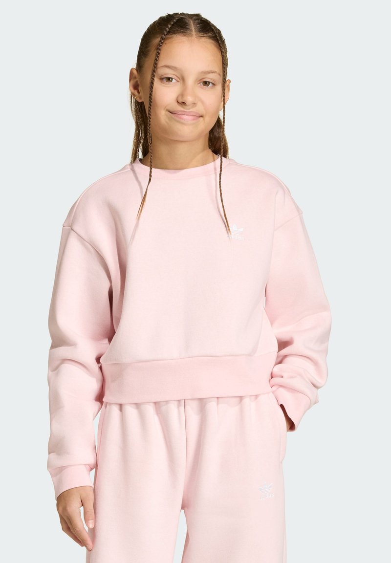 Ροζ φούτερ με στρογγυλή λαιμόκοψη, ριμπ μανσέτες και ελαστική γαζιά στη μέση. Διαθέτει λευκό λογότυπο Adidas στο στήθος. Μαλακό, υφή υφάσματος.