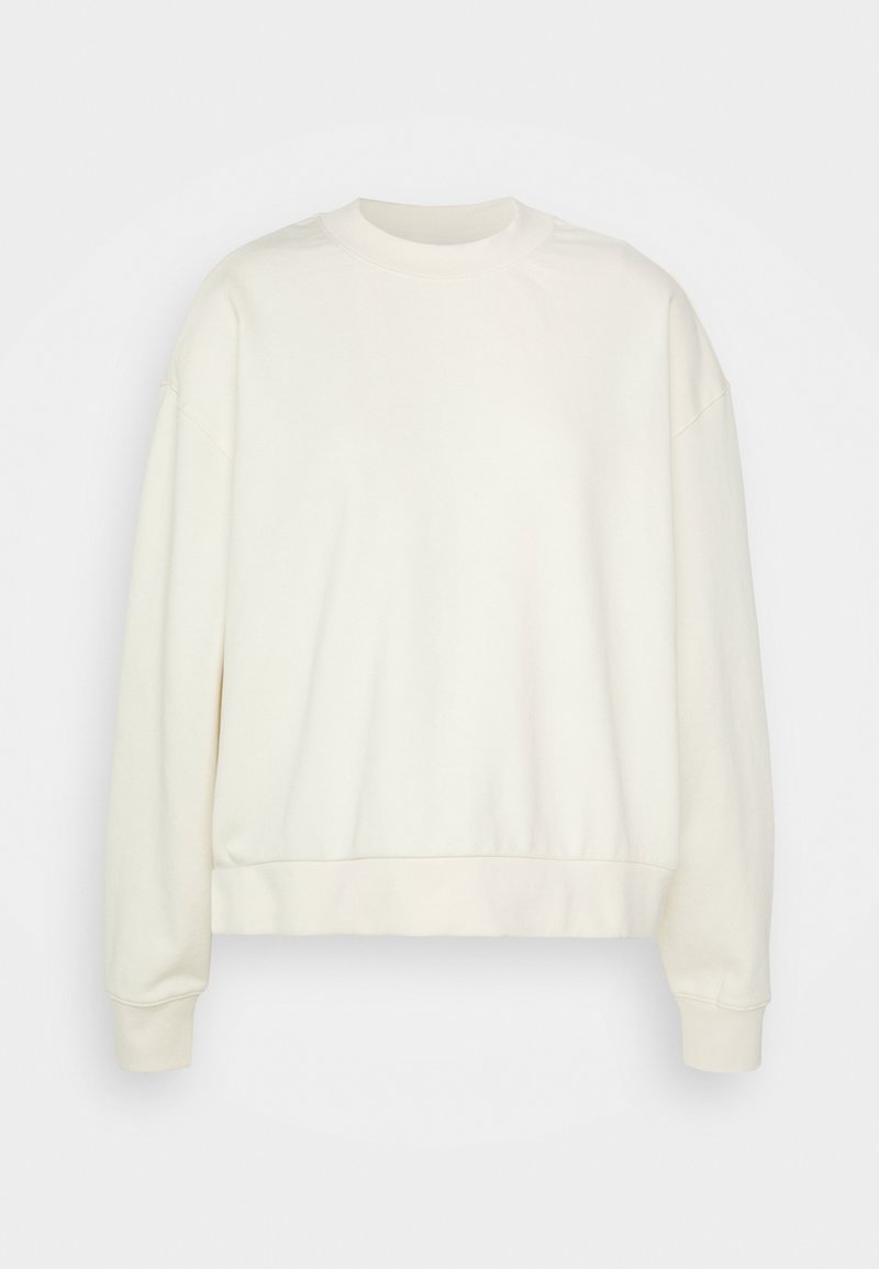 Sweat-shirt à col rond couleur écru uni avec manches longues et poignets et ourlet côtelés, présenté sur un fond blanc.