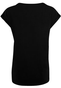 Haut noir à manches courtes en tissu doux. Il présente un col rond et une coupe ample, avec une texture lisse et sans motifs visibles.