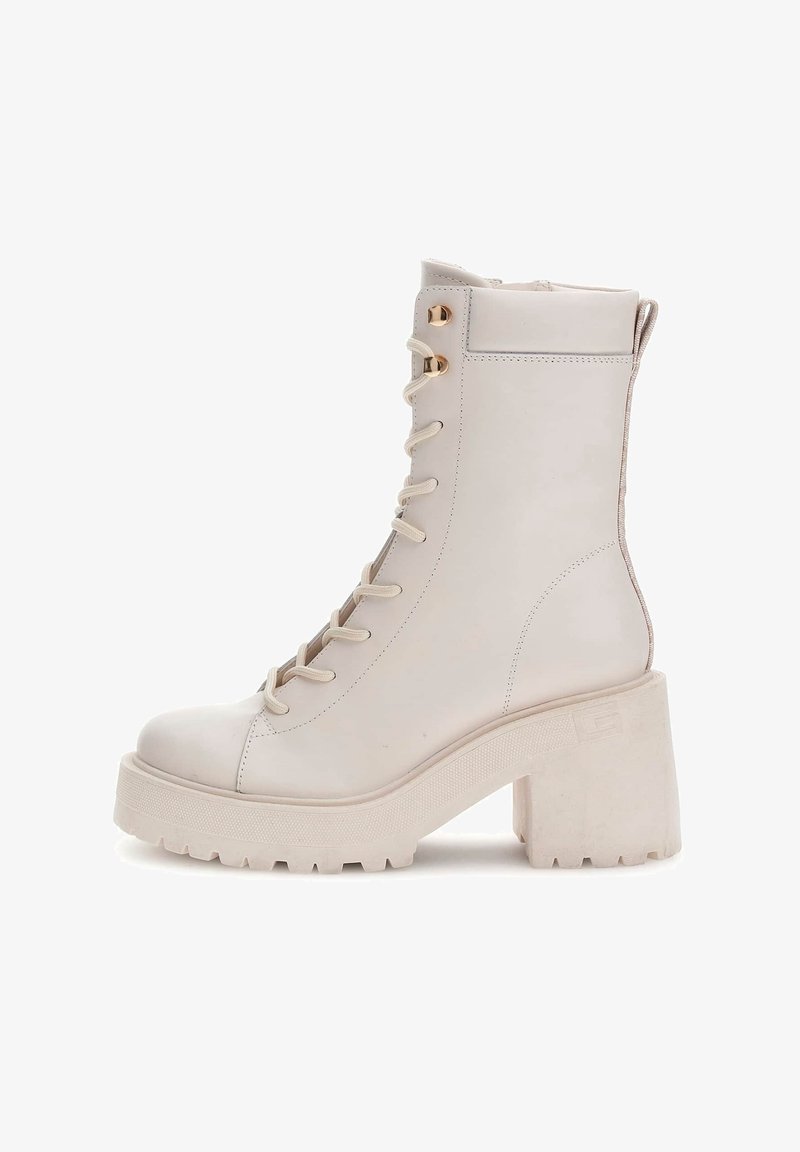 Bottine blanche en cuir avec plateforme et talon épais, dotée d'un design à lacets, d'œillets métalliques et d'une semelle texturée.