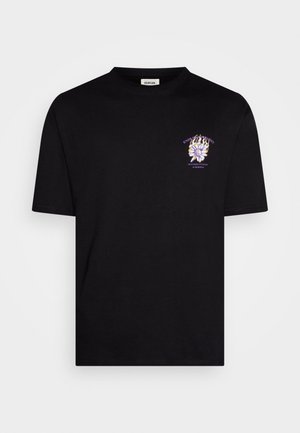 Schwarzes T-Shirt mit kurzen Ärmeln und kleinem lila-weißem Motiv einer Blume und Flammen auf der linken Brust, inklusive Text ober- und unterhalb des Motivs.