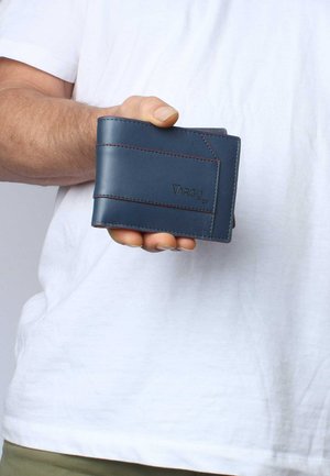 Blue leather wallet with contrasting red stitching, featuring a minimalist design and geometric accents, held in a hand.