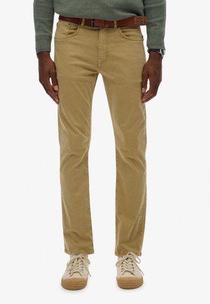 Khaki chinos med en slim fit, lavet af bomuld, med forlommer, baglomme og et brunt læderbælte. Stylet med lette sneakers.