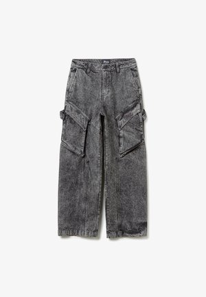 Cargo pants made of faded black denim, featuring large side pockets, a relaxed fit, and visible stitching details.