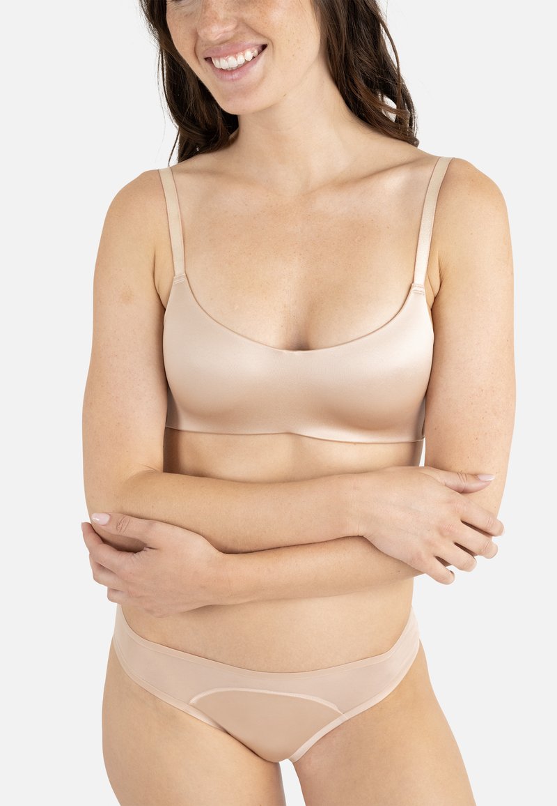Soutien-gorge beige clair et culotte de bikini assortie en tissu lisse. Le soutien-gorge présente des fines bretelles et un design simple et sans couture.