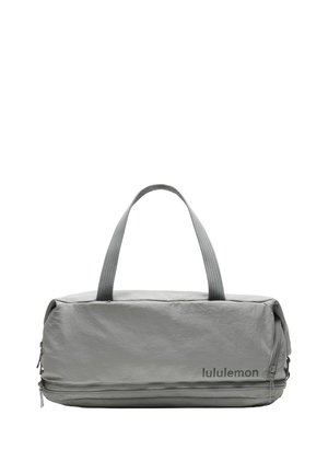 Bolsa de deporte gris Lululemon con dos asas y un bolsillo ancho con cremallera en la parte inferior del frente.