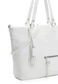 Sac fourre-tout en simili cuir blanc avec double poignée, bandoulière réglable, poche zippée et détail à frange sur le côté.