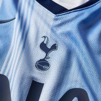 Himmelblaues Sporttrikot mit strukturiertem Design, dunklem Marinekragen und einem auffälligen Spurs-Logo mit einer Taube und einem Fußballgrafik.