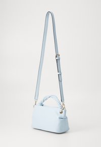 Borsa a spalla azzurro chiaro con manico superiore attorcigliato e finitura liscia e testurizzata. Dotata di una tracolla regolabile e hardware in tonalità argento.