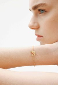 Pulsera de oro con un diseño de camaleón. La cadena es delicada con un acabado texturizado, destacando los finos detalles del camaleón.