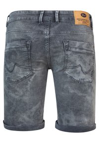Denim shorts i en bleknad gråtvätt har en rullad fåll, två bakfickor med synlig sömnad och en märkesläderpatch vid midjan.