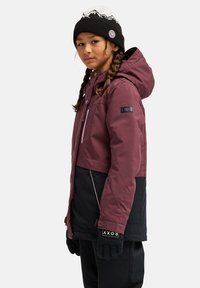 Bordeauxrood en zwarte geïsoleerde skijas met capuchon, voorzien van contrasterende stiknaden, een ritszak en een merkpatch op de mouw. Inclusief zwarte handschoenen.