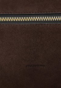 Brūna zamšādas somiņa ar zeltītu rāvējslēdzēju, ar gludu tekstūru un iespiestu zīmola nosaukumu "ALLSAINTS" pie pamatnes.