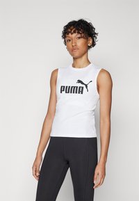 Hvit ermeløs topp med svart "PUMA"-logo og kattsilhuett. Laget av et glatt, lett stoff, kombinert med svarte leggings.