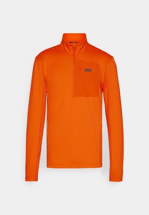 Oranges Langarmoberteil mit einem Halb-Zip-Kragen, ausgestattet mit einer Brusttasche und einem dezenten Logo. Hergestellt aus strukturiertem, atmungsaktivem Material.