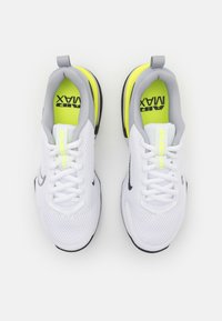 Et par hvide og grå Nike Air Max sneakers med neongule indlæg og sorte såler, set ovenfra på en hvid baggrund.