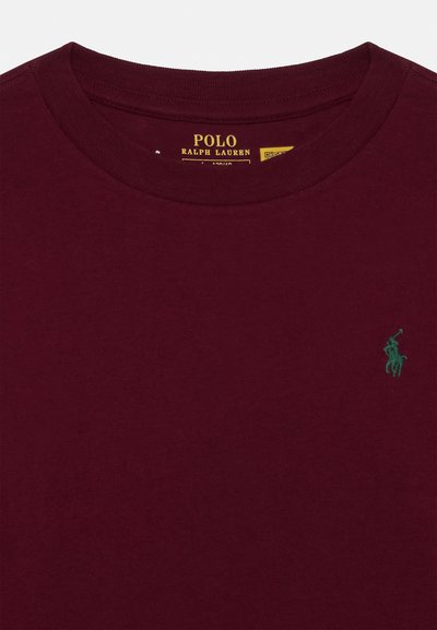 Burguny színű pamut póló, kerek nyakkivágással és zöld hímzett polo játékos emblémával a mellen. Simább textúrájú, rövid ujjú.