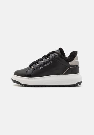 Czarny niskoprofilowy sneaker z białą podeszwą, metalowymi oczkami na sznurówki, podszewką z imitacji futra i logo "KARL LAGERFELD" z boku oraz na pięcie.