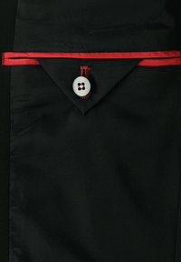 Schwarzer Stoff mit einem roten Satinakzent, der eine spitze Lasche und einen großen weißen Knopf mit einem schwarzen Punktmuster in der Mitte aufweist.