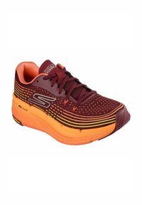 Scarpa sportiva a rete rossa e arancione con una parte superiore texturizzata, accentuata da strisce gialle e una suola ammortizzata. Presenta lacci e dettagli con logo.