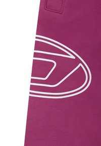 Fuchsia stof met een groot wit geometrisch logo en gebogen lijnaccenten. Glad oppervlak met zichtbare stikdetails.